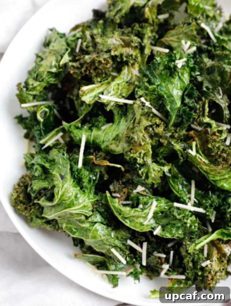 Air-Fried Kale: Your Crunchy Snack Fix 8 Close-up of golden brown, perfectly crispy kale chips on a white plate, invitingly ready to be enjoyed.