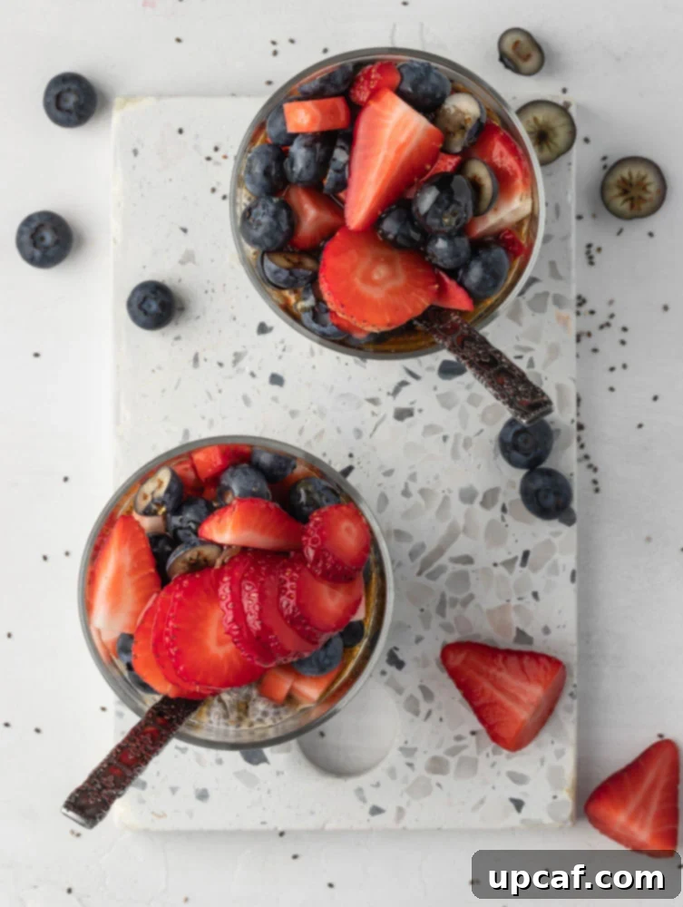 Top-down shot of a beautifully prepared chia seed pudding, highlighting the layered textures and colorful fresh fruit toppings like blueberries and pomegranate seeds.