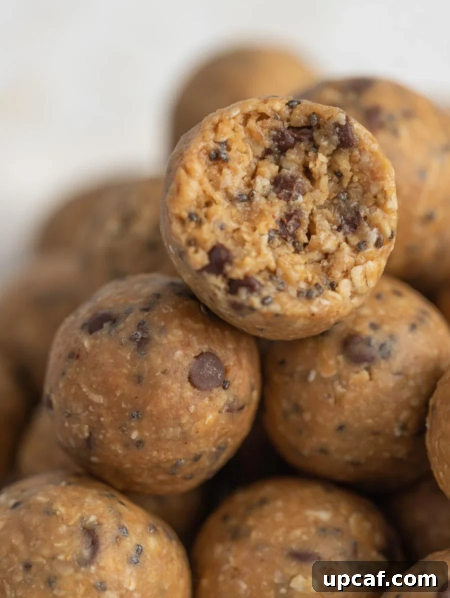 Close-up of a perfectly formed No-Bake Energy Ball with a bite taken out, revealing its wholesome interior.