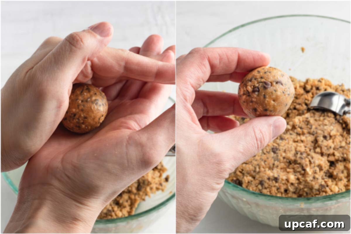 A pair of hands demonstrating the rolling technique for forming a uniform energy ball.