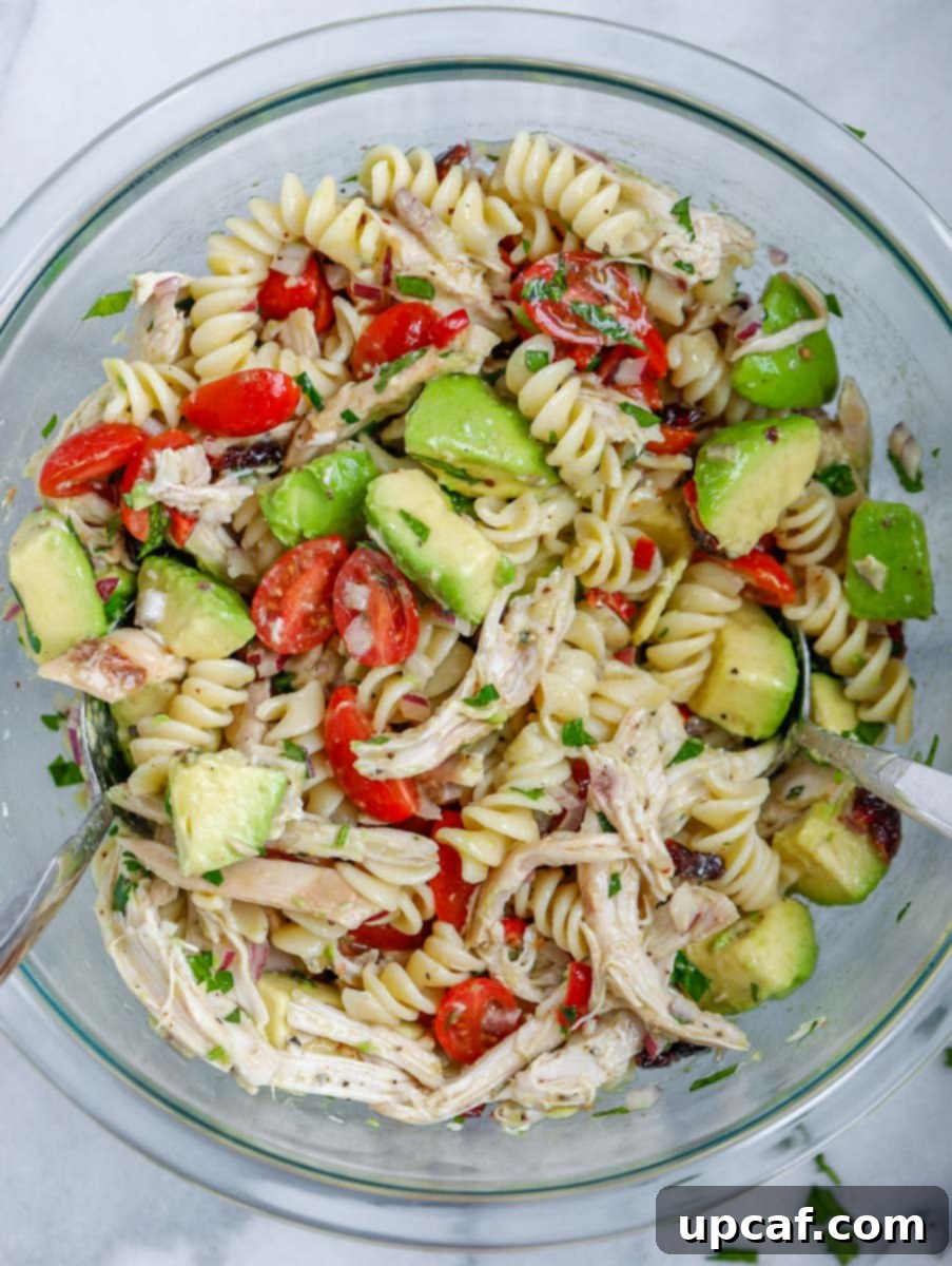 A close-up shot of the finished avocado chicken pasta salad, mixed and ready to enjoy.