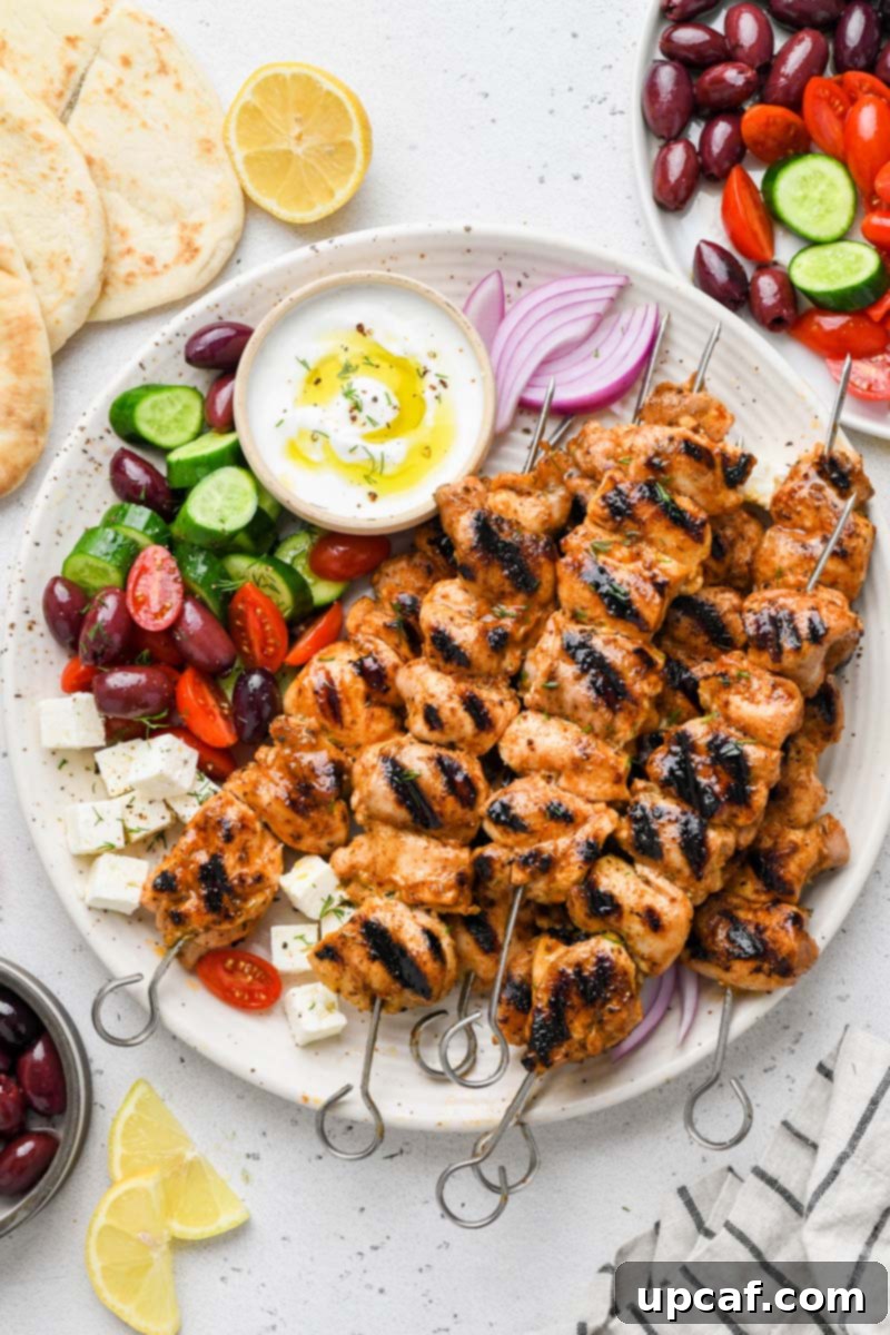 Top-down shot of vibrant Lemon Garlic Chicken Skewers styled on a plate with fresh lemon slices and herbs.