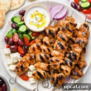 Top-down shot of vibrant Lemon Garlic Chicken Skewers styled on a plate with fresh lemon slices and herbs.