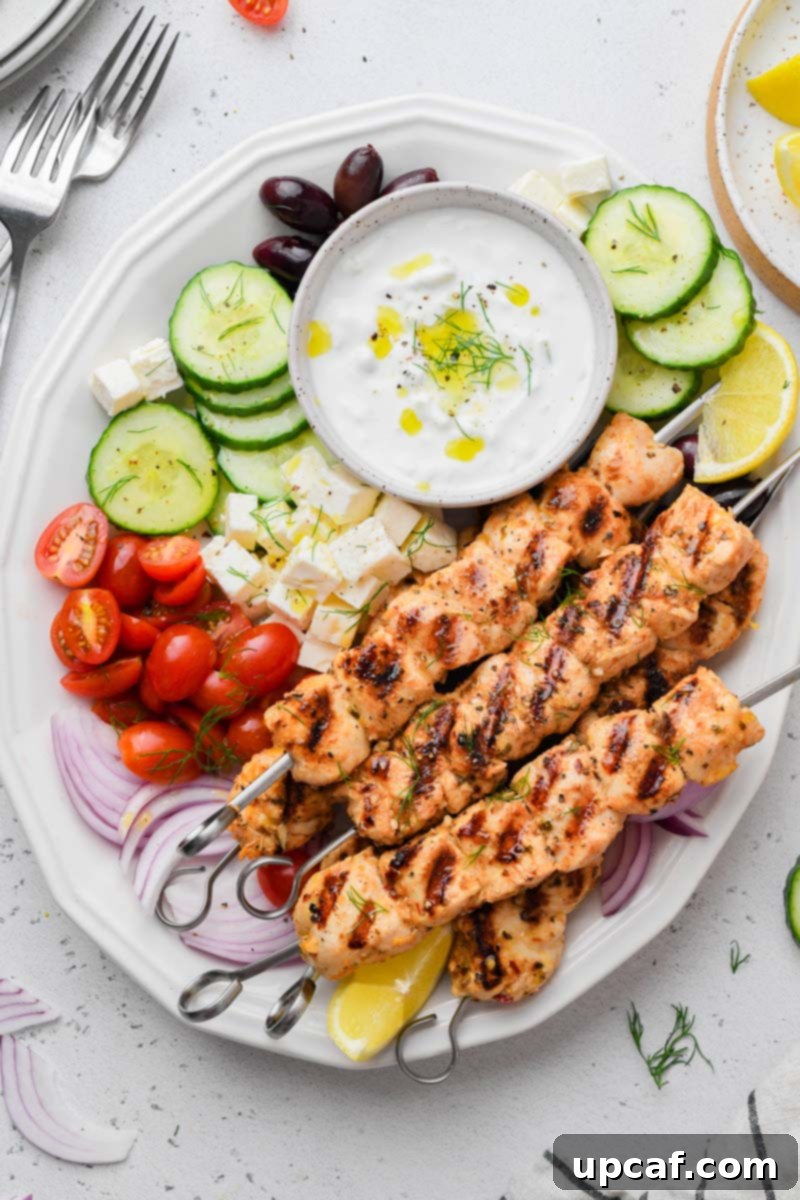 Lemon-Oregano Grilled Chicken Skewers 2 Top-down shot of vibrant Grilled Greek Chicken Skewers served with fresh sides