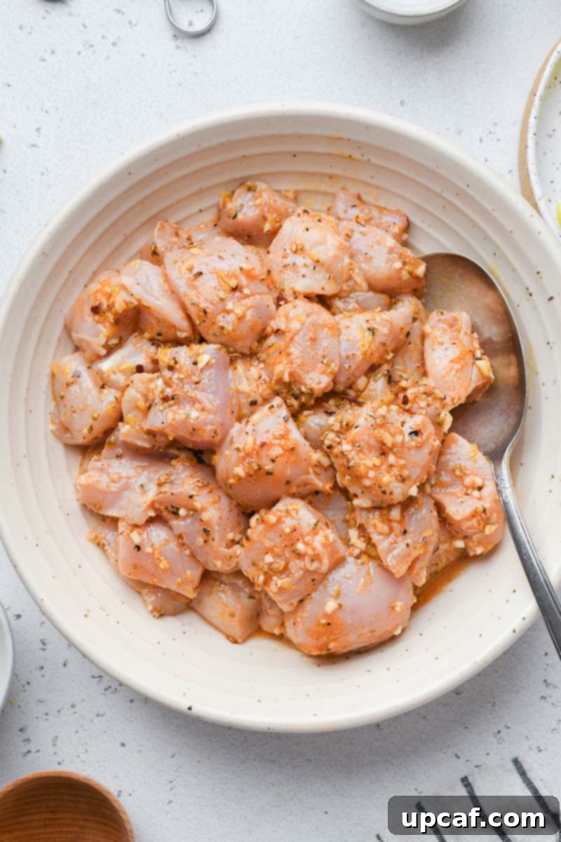 Lemon-Oregano Grilled Chicken Skewers 4 Marinated chicken cubes resting in a bowl, ready for skewering