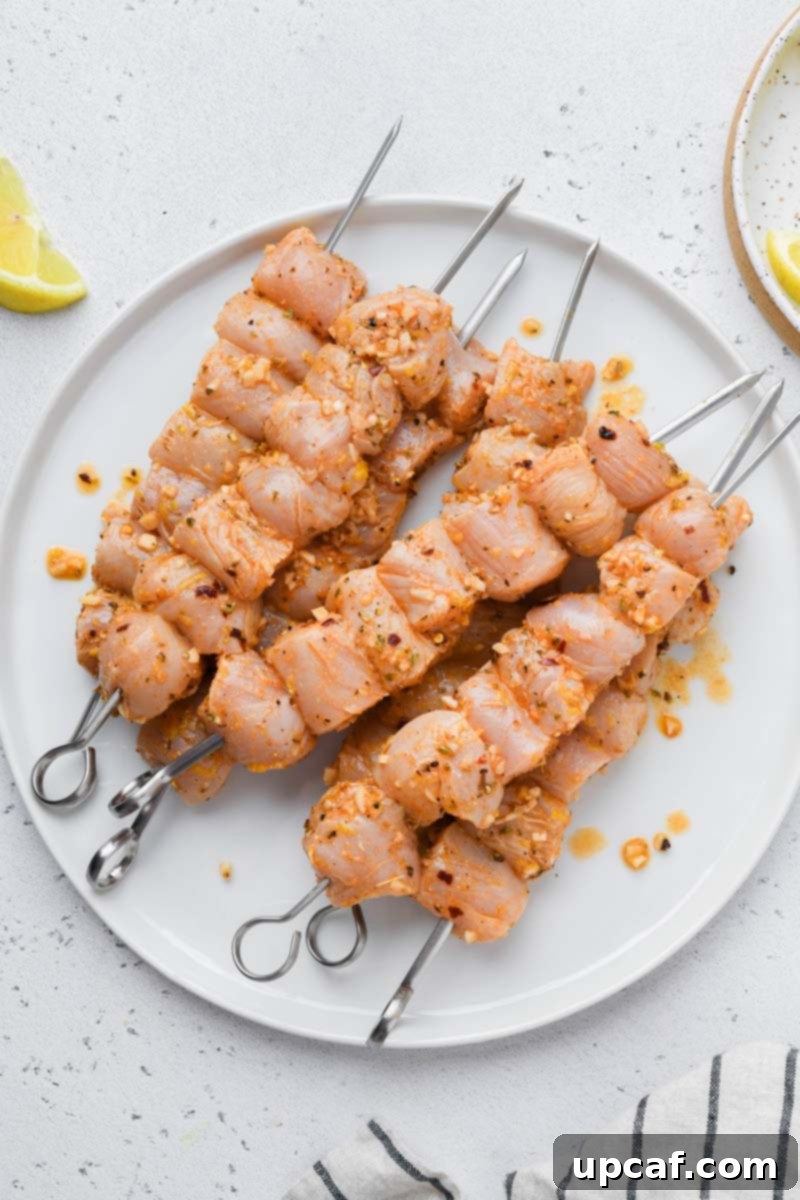 Lemon-Oregano Grilled Chicken Skewers 5 Marinated Greek chicken skewers arranged before being placed on the grill