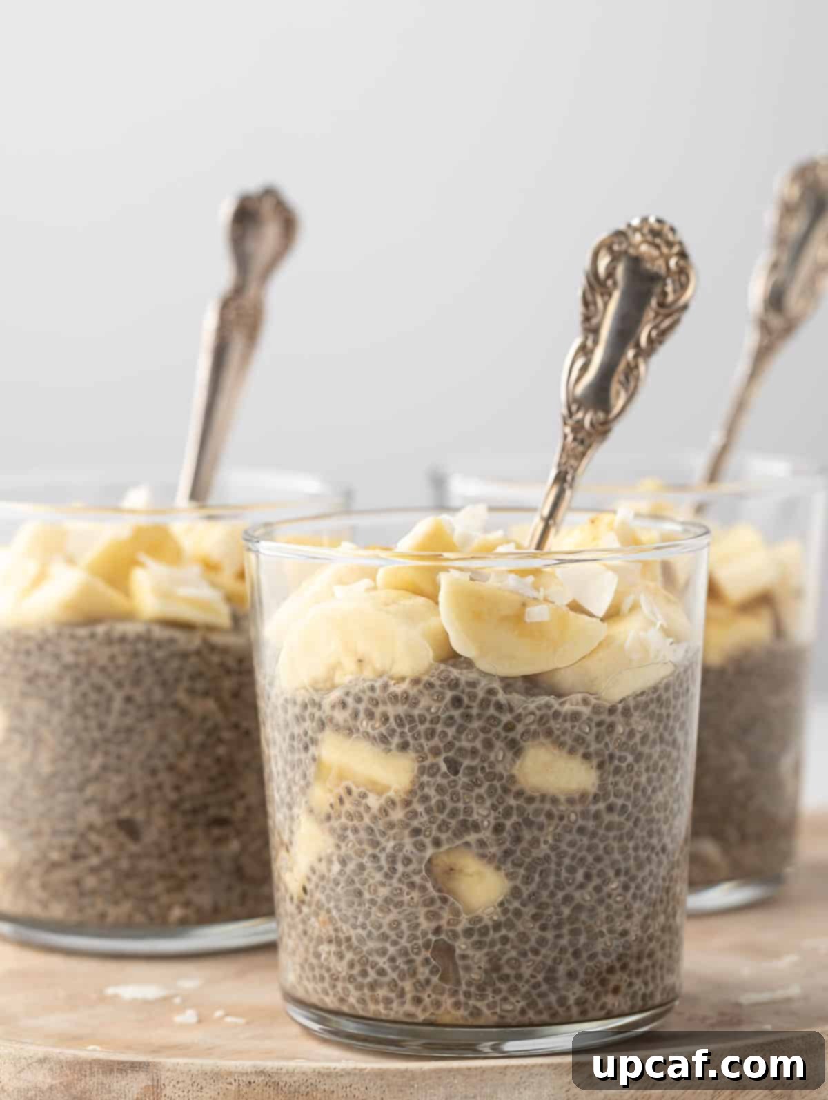 banana chia pudding in a transparent cup with a spoon inside, ready to be eaten