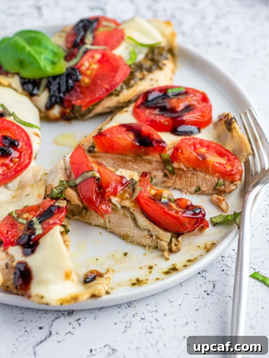Caprese chicken sliced into portions, showcasing the juicy interior and melted cheese