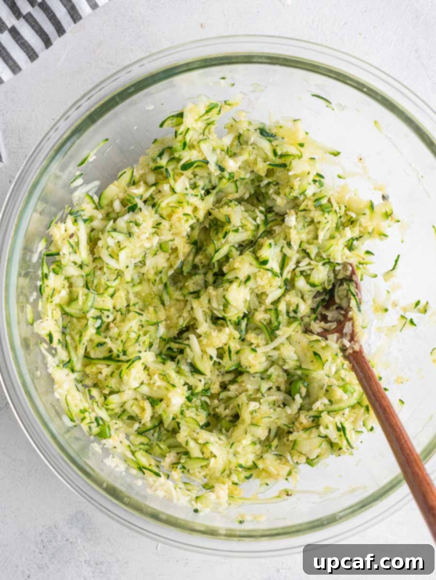 Crispy Zucchini Pancakes 6 The zucchini fritter mixture after all ingredients have been thoroughly combined in a glass bowl.