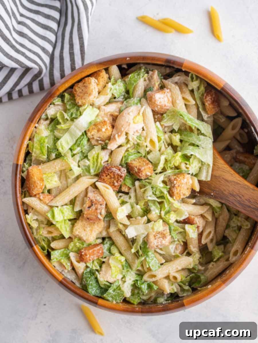 chicken caesar pasta salad in a wooden bowl
