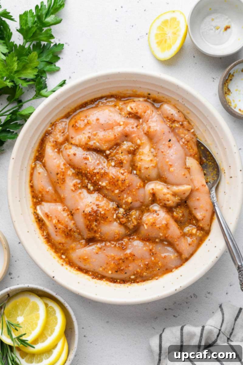 Bowl of chicken tenders marinaded in honey mustard sauce.