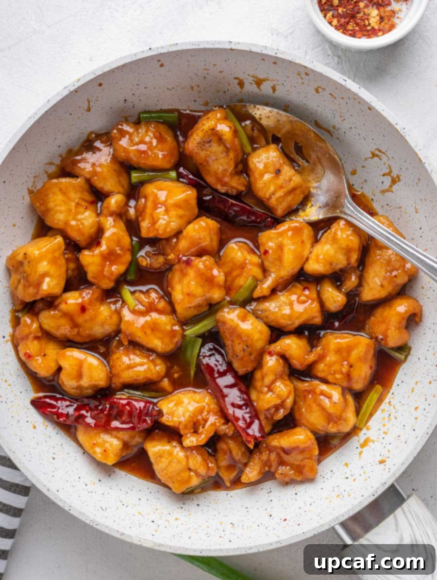 Quick Sticky Mongolian Chicken 8 mongolian chicken in a skillet with a serving spoon