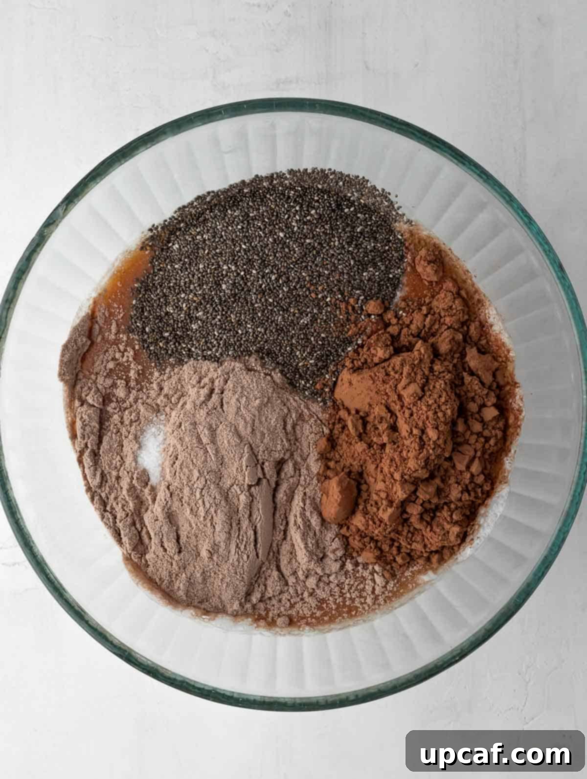 ingredients of chocolate protein chia pudding in bowl before mixing