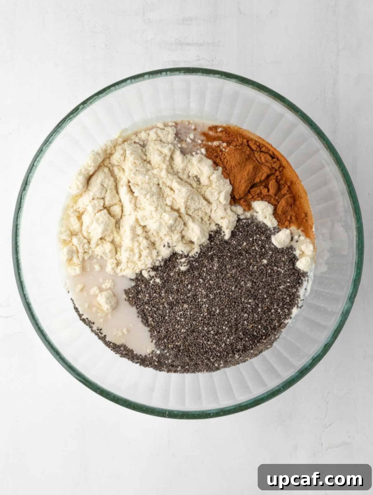 all ingredients of the cinnamon apple Overnight Chia pudding in a bowl before mixing