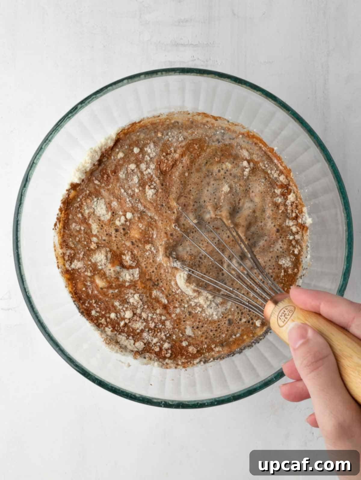 whisk mixing all ingredients together in a bowl.