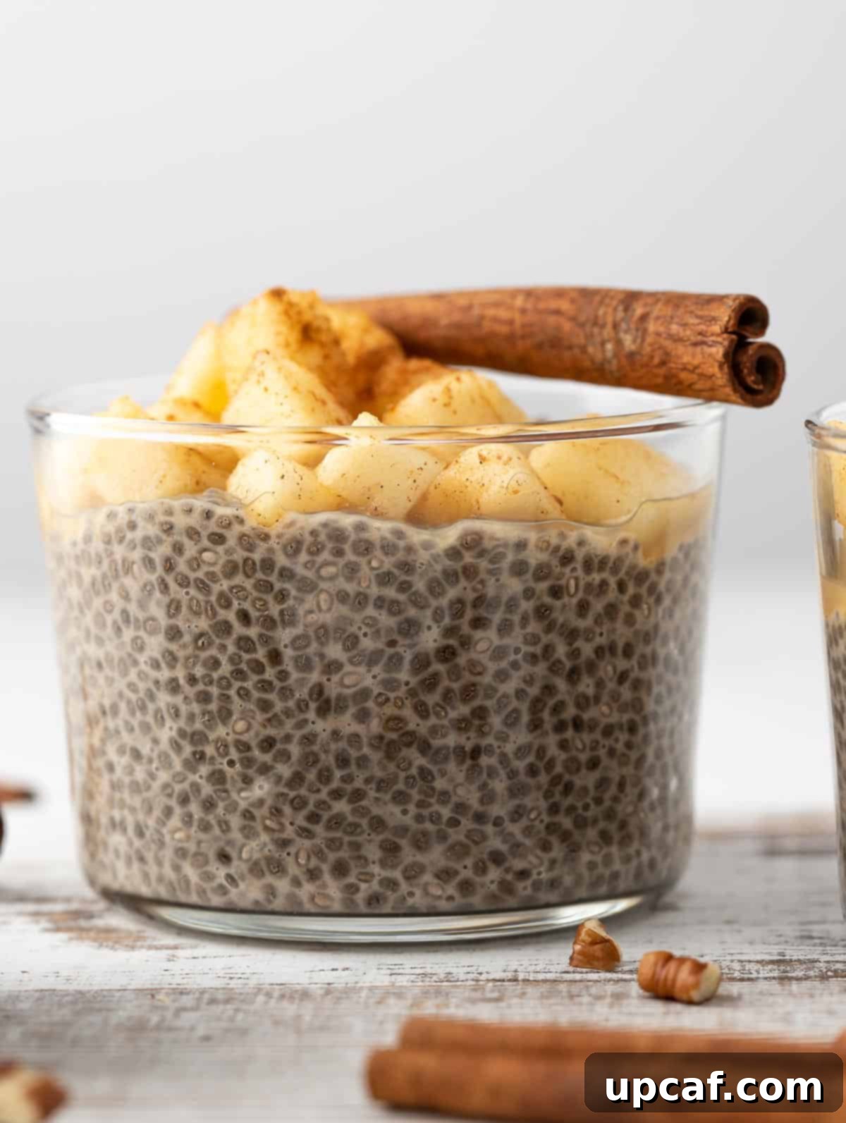 Overnight Chia Pudding topped with apples and a cinnamon stick.