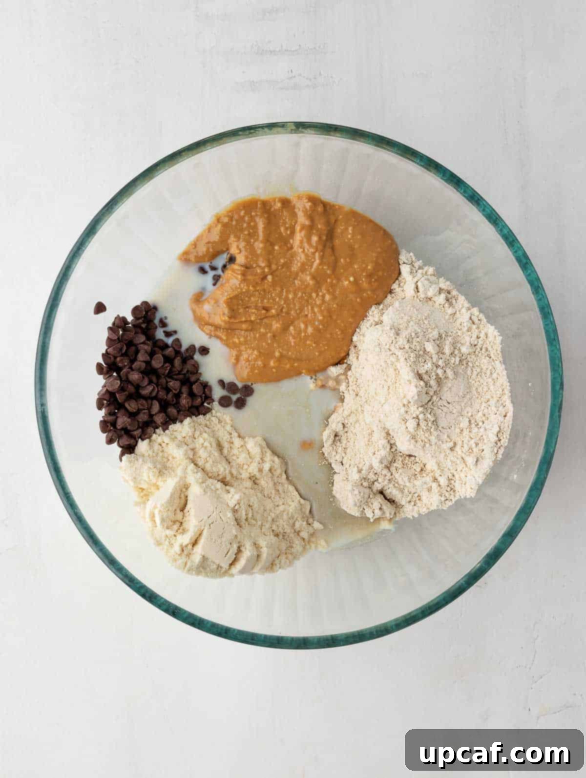 All protein cookie dough ingredients neatly placed in a large bowl, ready for mixing.