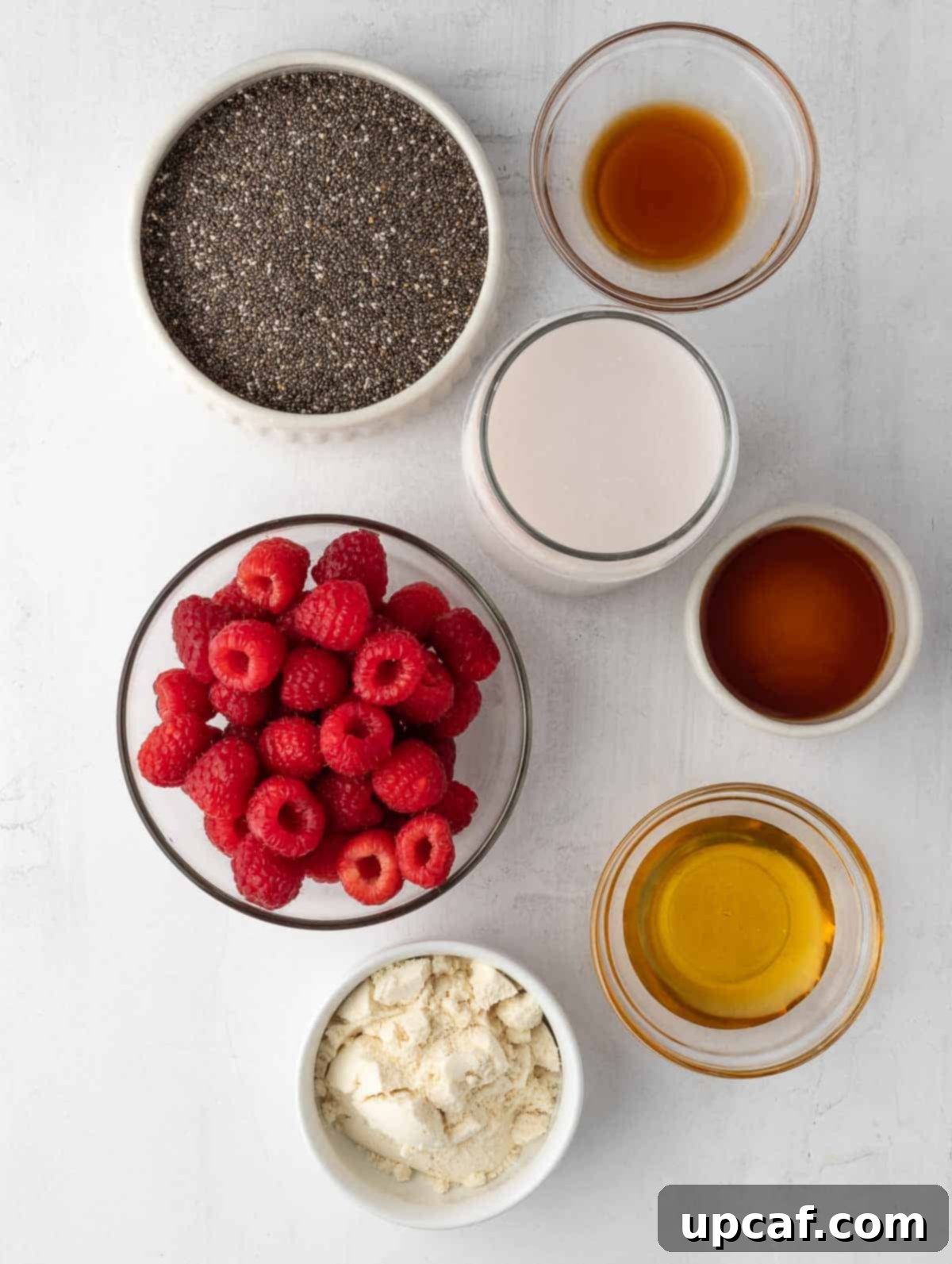 Vibrant Raspberry Chia Pudding 3 All the fresh ingredients for Raspberry Protein Chia Seed Pudding laid out neatly on a surface.
