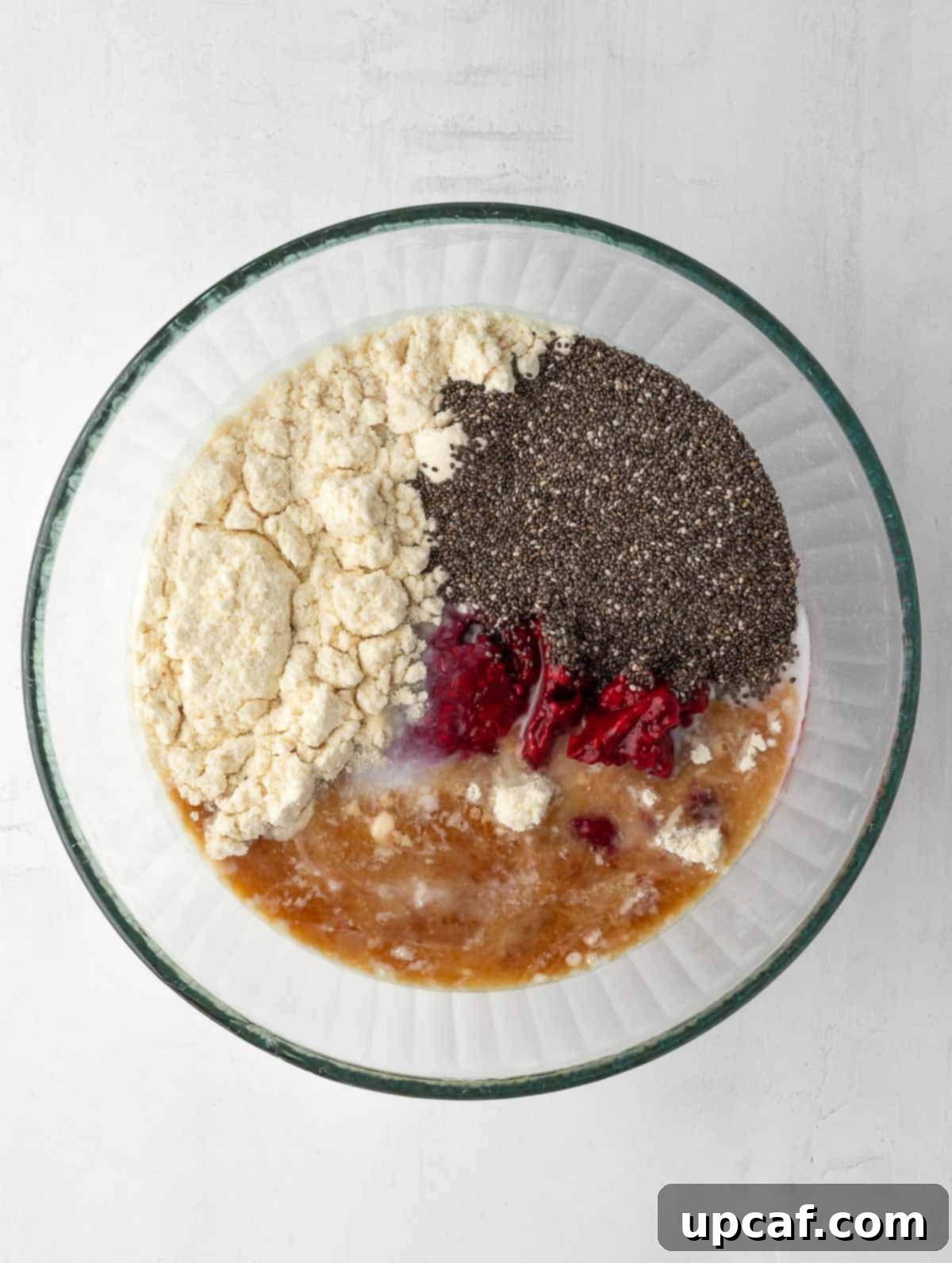 Vibrant Raspberry Chia Pudding 4 All the ingredients for raspberry protein chia pudding are placed in a bowl, ready to be mixed.
