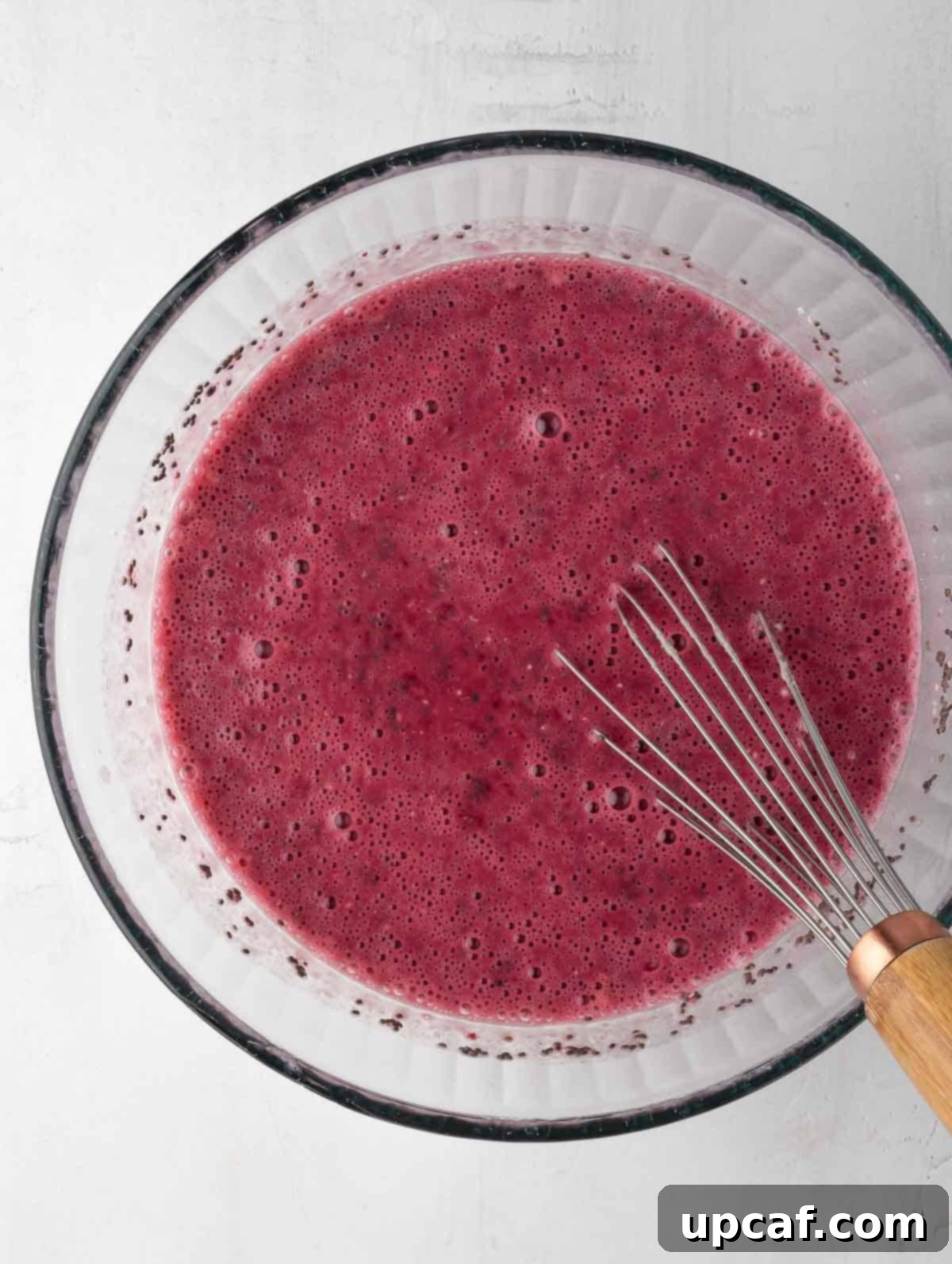 Vibrant Raspberry Chia Pudding 5 All ingredients for the raspberry protein chia pudding are thoroughly mixed in a bowl with a whisk.