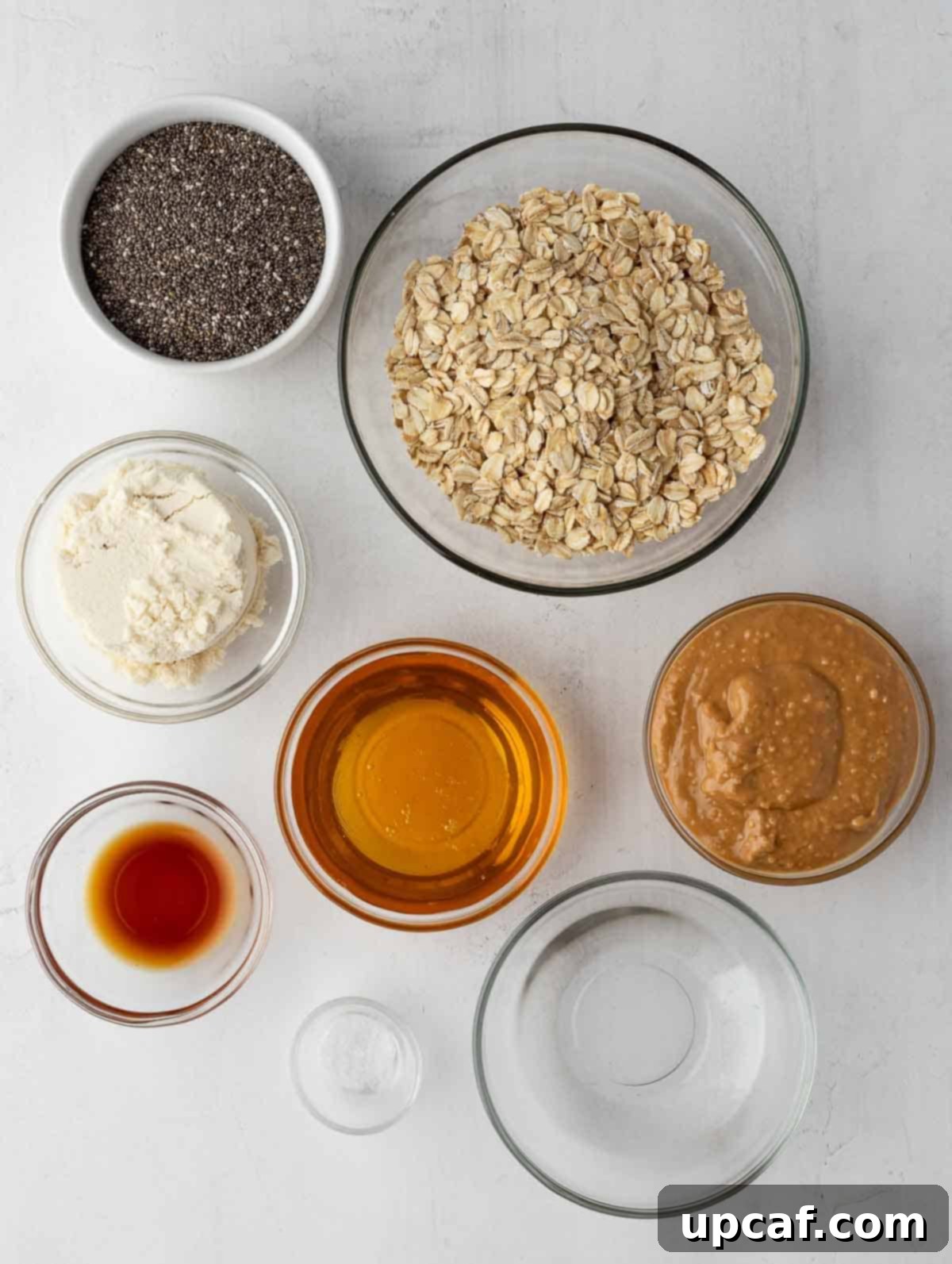 Vanilla Protein Power Bites 3 Assortment of ingredients for vanilla protein energy balls laid out on a white surface