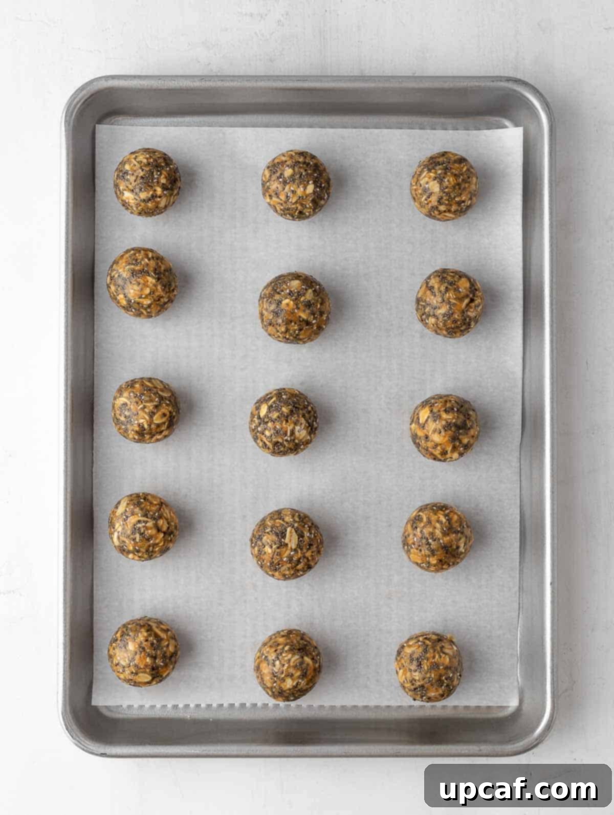 Vanilla Protein Power Bites 6 Finished energy balls neatly arranged on a parchment-lined sheet pan for chilling