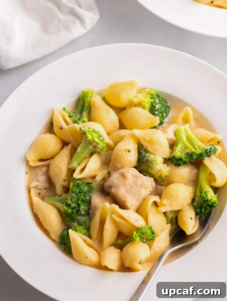 creamy broccoli mac and cheese in a white place with a fork