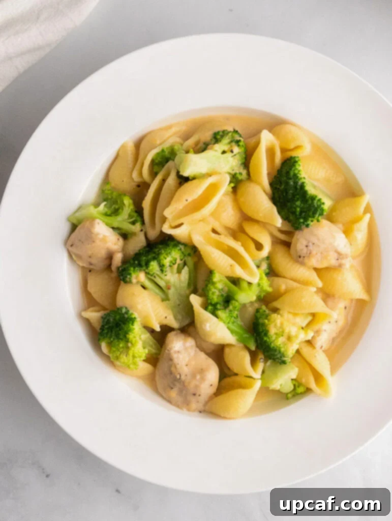 creamy broccoli chicken mac and cheese served on a white plate