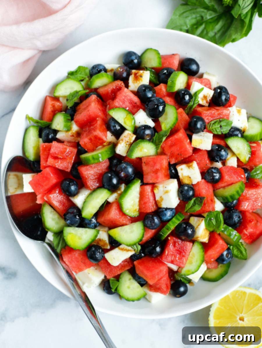 top down shot of watermelon feta salad in a bowl with a spoon