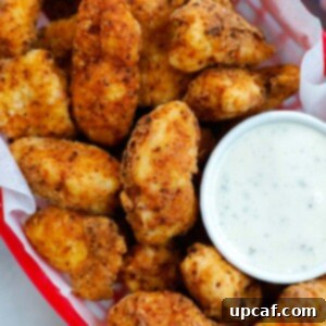 Crispy chicken bites in a red basket with a side of ranch