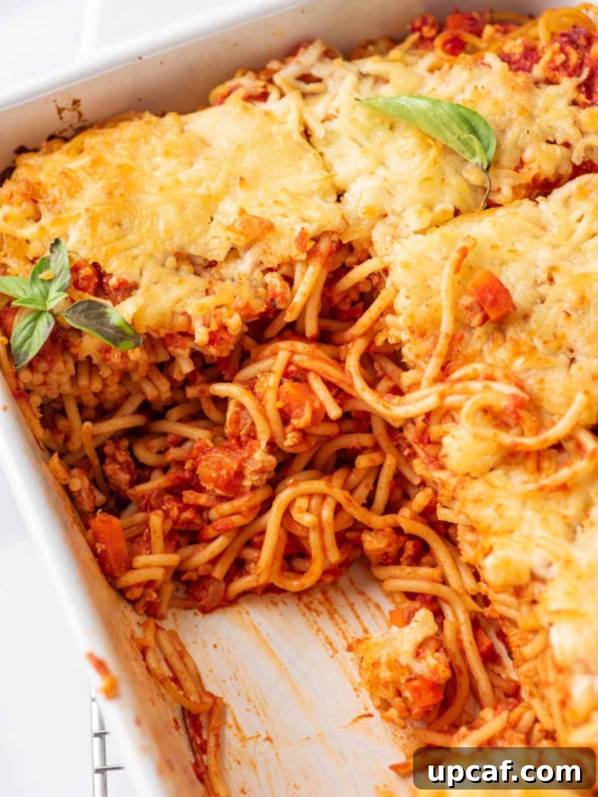 A large dish of easy baked spaghetti, perfectly golden brown and inviting, placed centrally for serving.