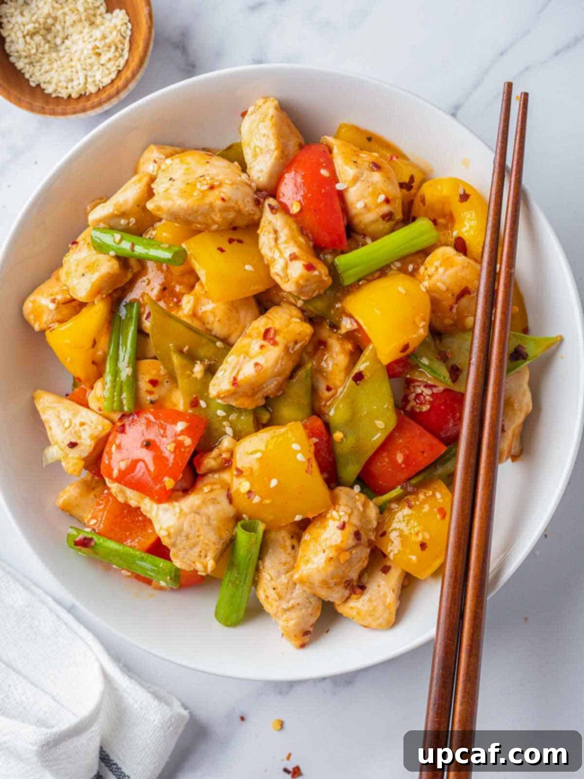 A plate of Szechuan chicken with chopsticks on the side, ready to be enjoyed.