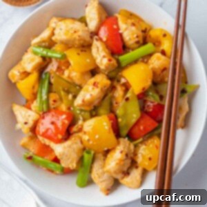 A plate of Szechuan chicken with chopsticks on the side.