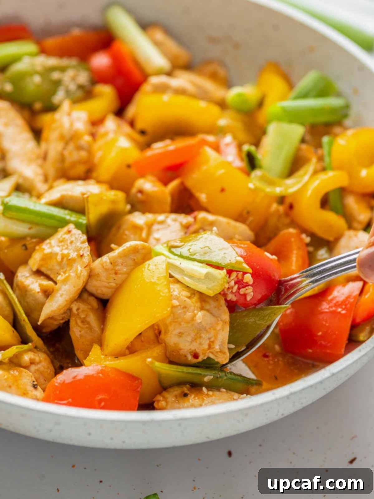 A vibrant plate of Szechuan chicken, garnished and ready to eat.