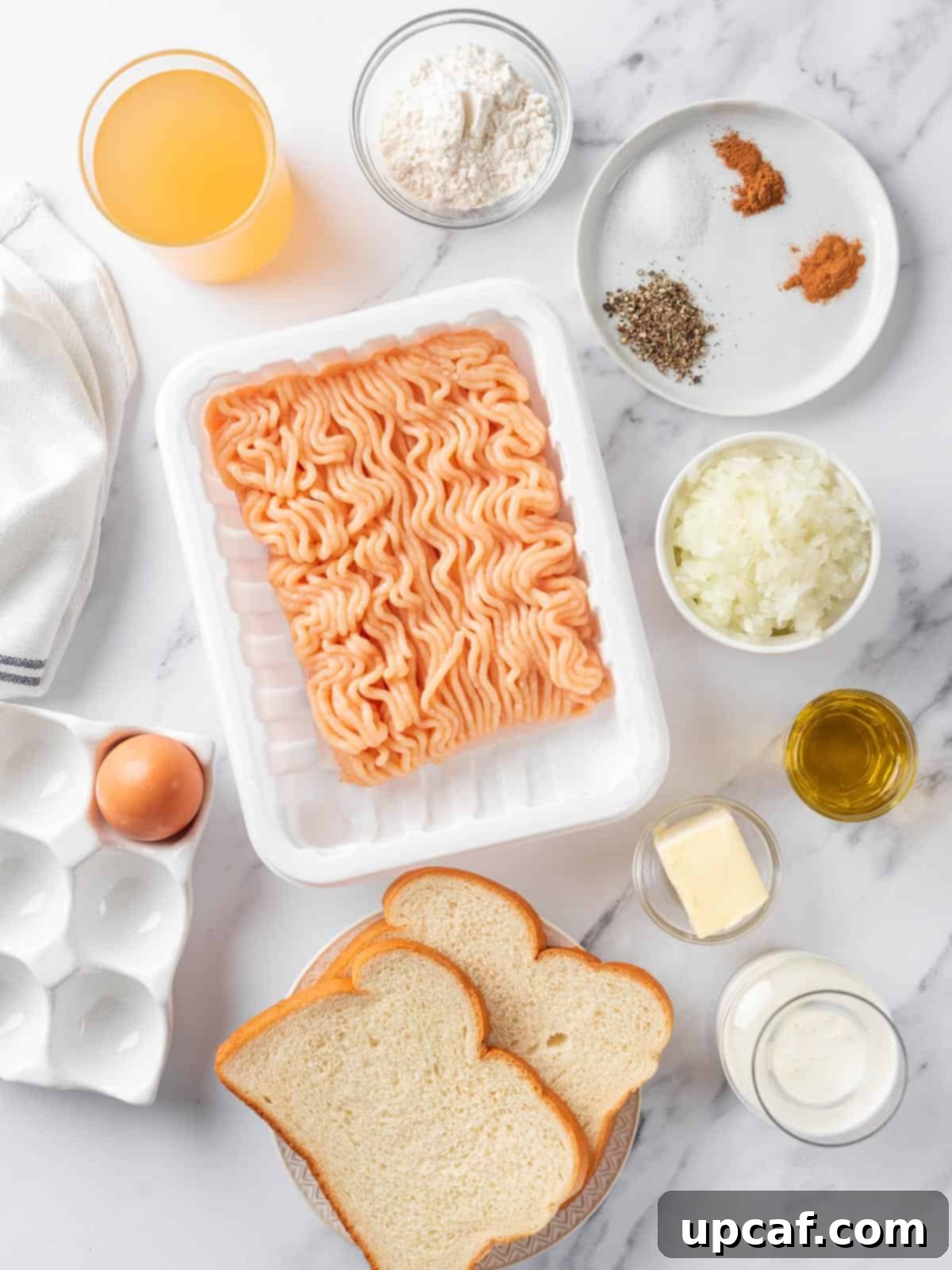 A selection of fresh ingredients laid out on a wooden board, ready to make Swedish Chicken Meatballs.
