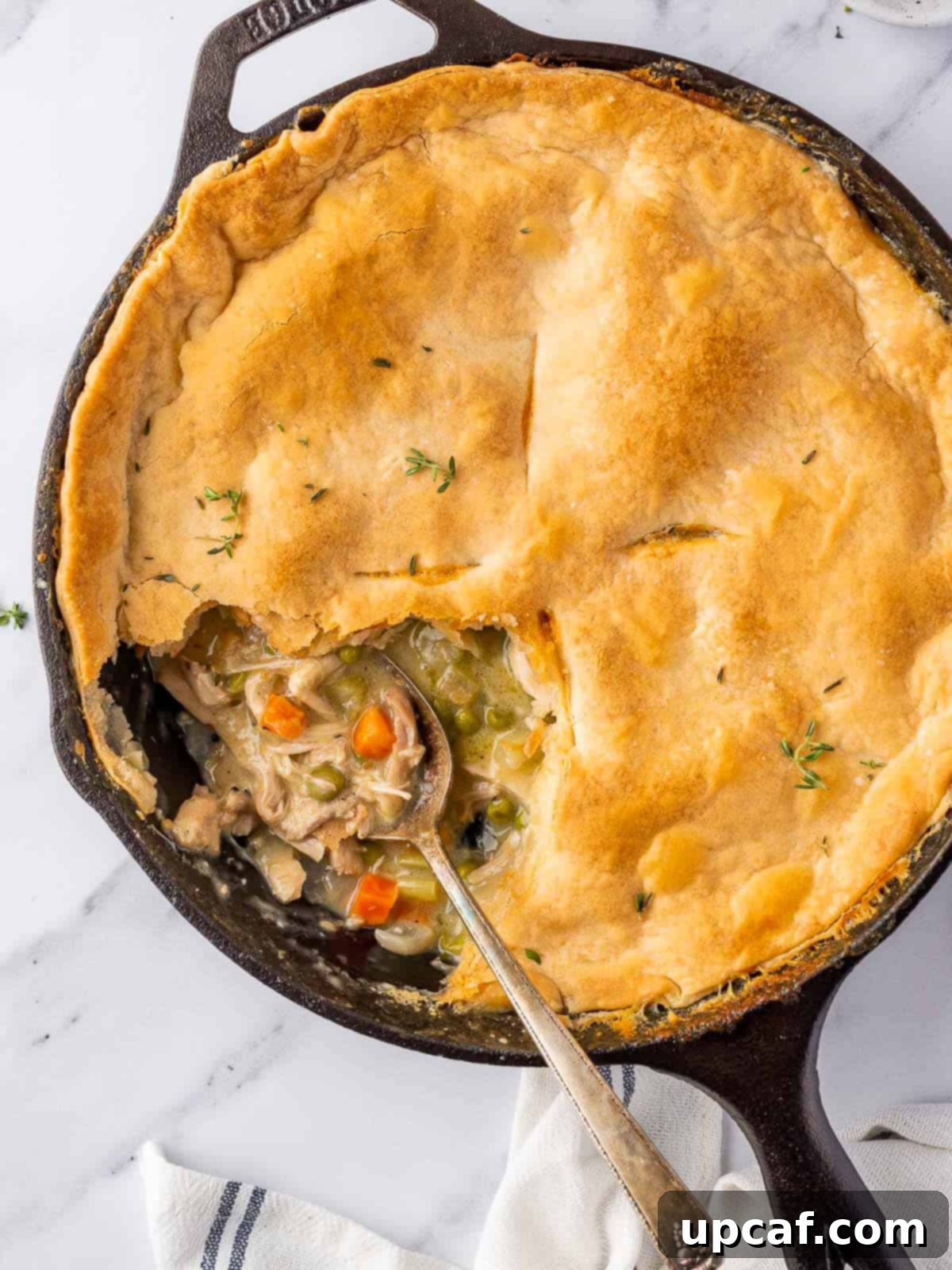 spoon in the skillet with a portion of pot pie removed