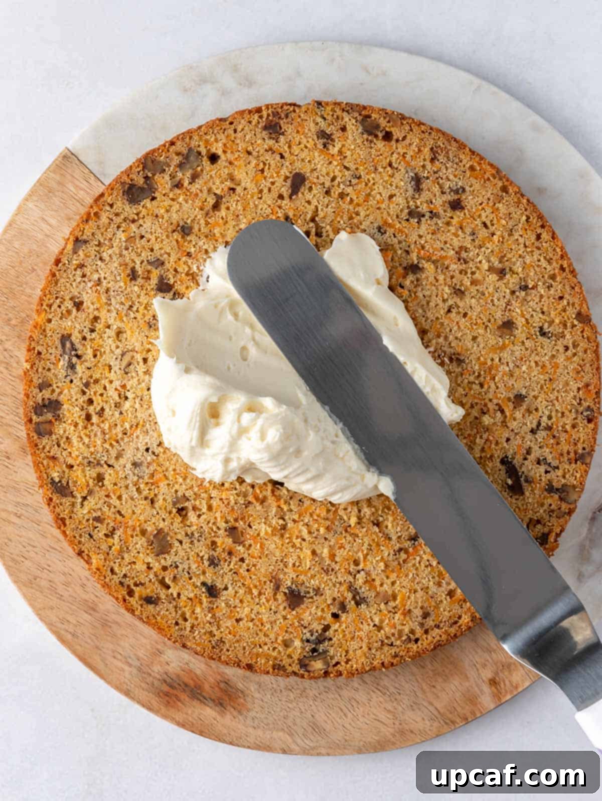 cream cheese frosting applied into cake layers