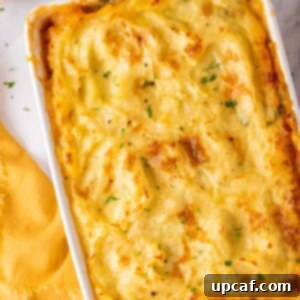 Chicken Shepherds pie in a white baking dish, garnished with parsley