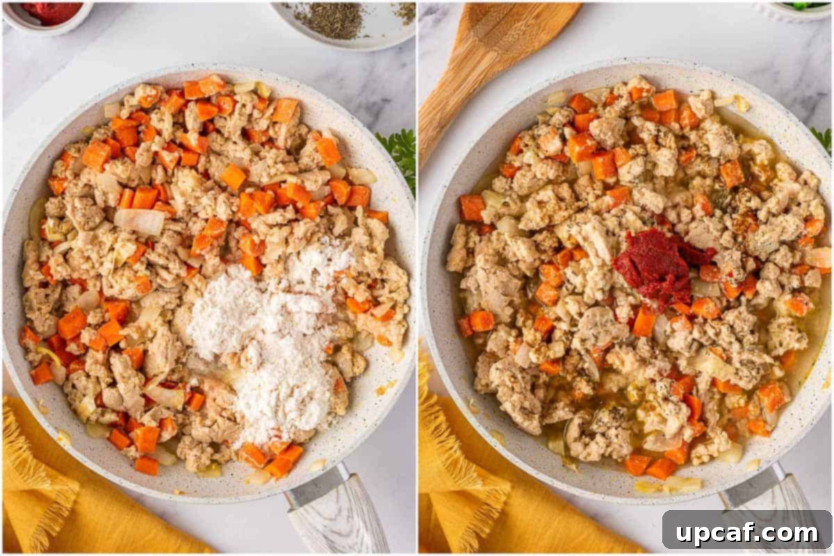 Close-up of the chicken and vegetable filling simmering in a skillet, coated in a rich, thick sauce.