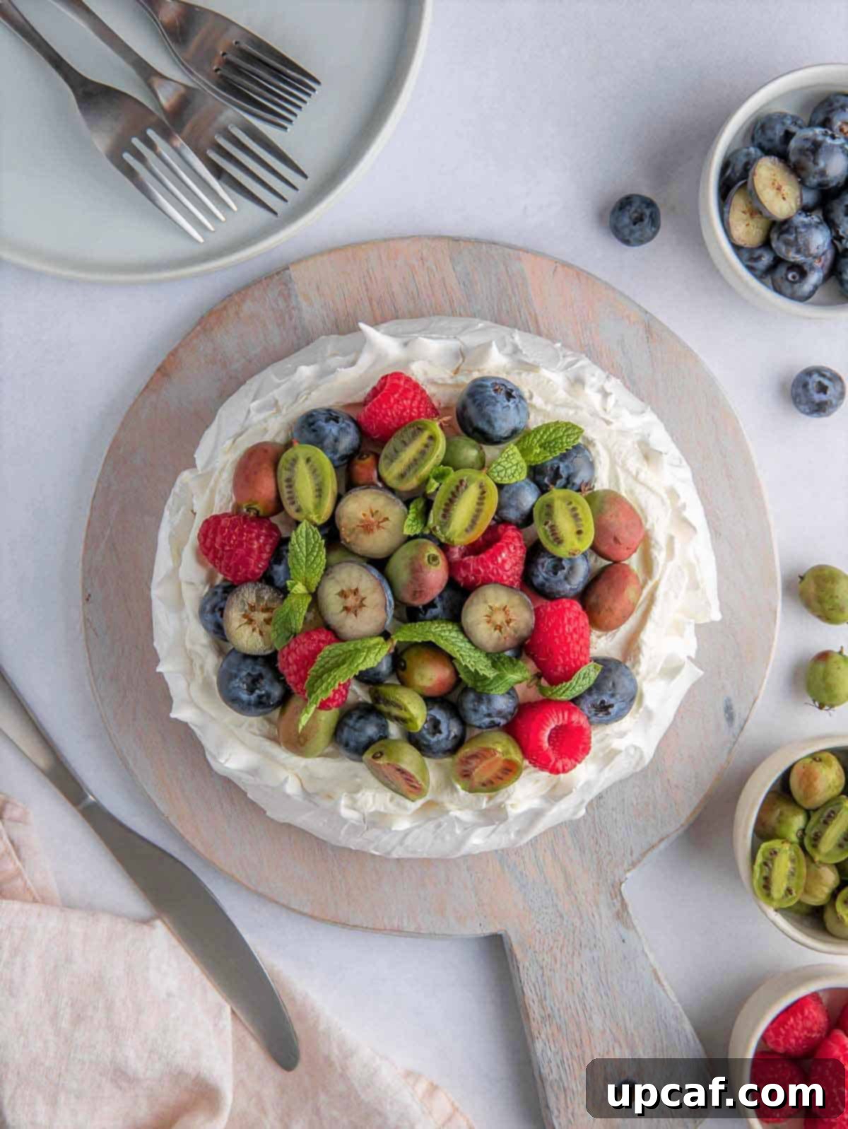 top down shot of berry pavlova cake on a wooden board