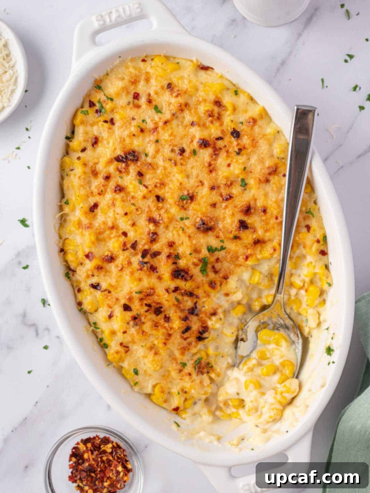 creamed corn casserole dish with a spoon in it, ready for serving