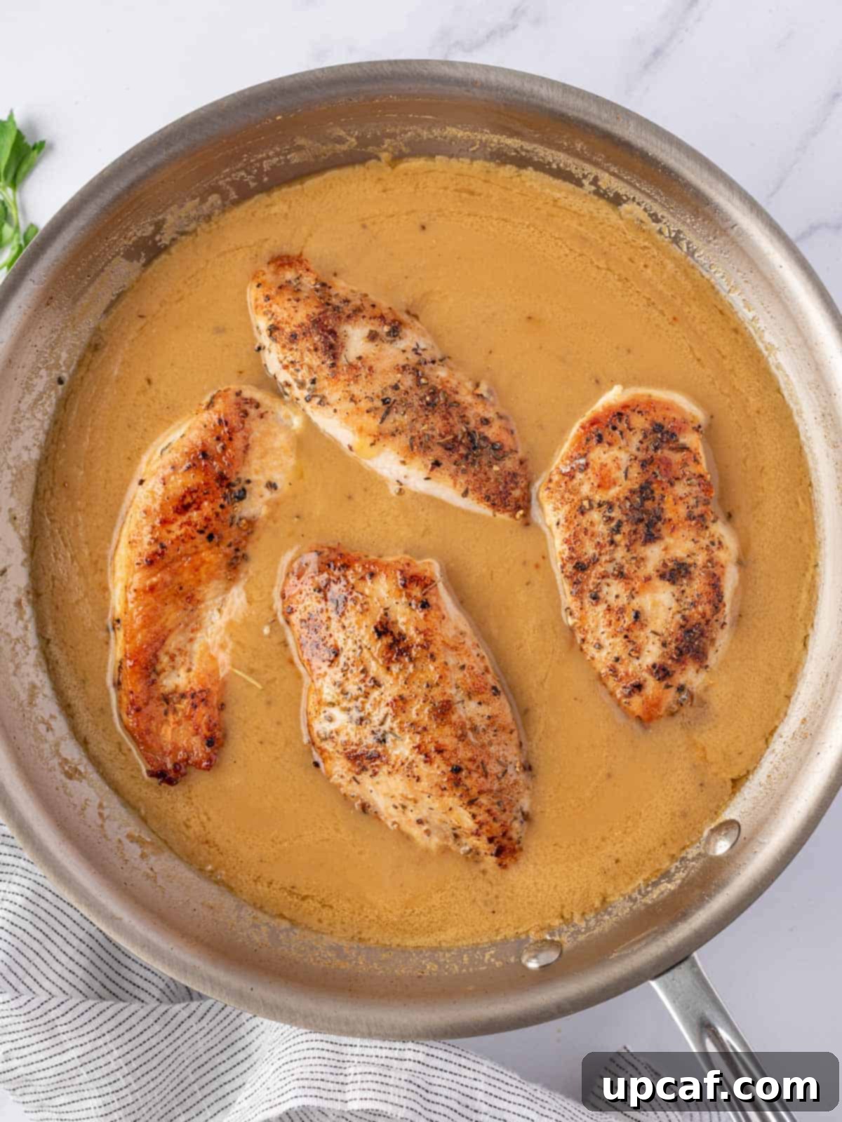 Effortless Chicken and Savory Gravy 6 The chicken pieces are added back into the pan of rich, simmering gravy for the final cooking stage.