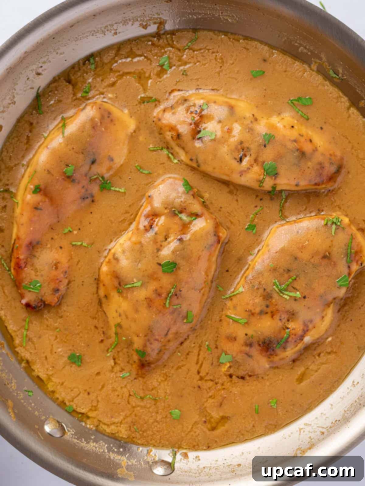 Effortless Chicken and Savory Gravy 7 A large skillet filled with perfectly cooked chicken breasts covered in savory gravy, ready to be served.