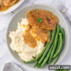 Effortless Chicken and Savory Gravy 10 A plate of chicken, gravy, mashed potatoes, and green beans.