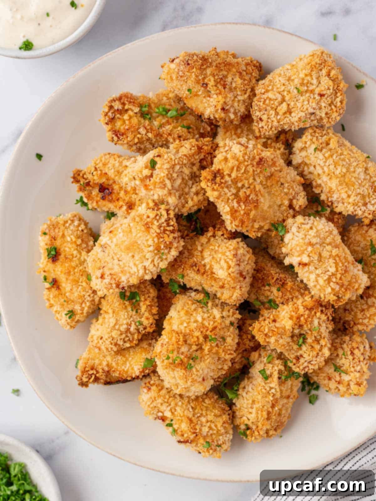 A neatly arranged plate of crispy, golden-brown popcorn chicken, ready to be served.