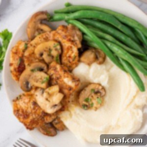 Flavorful Garlic Mushroom Chicken Thighs 9 A plate of mushroom garlic chicken thighs with mashed potatoes and green beans.