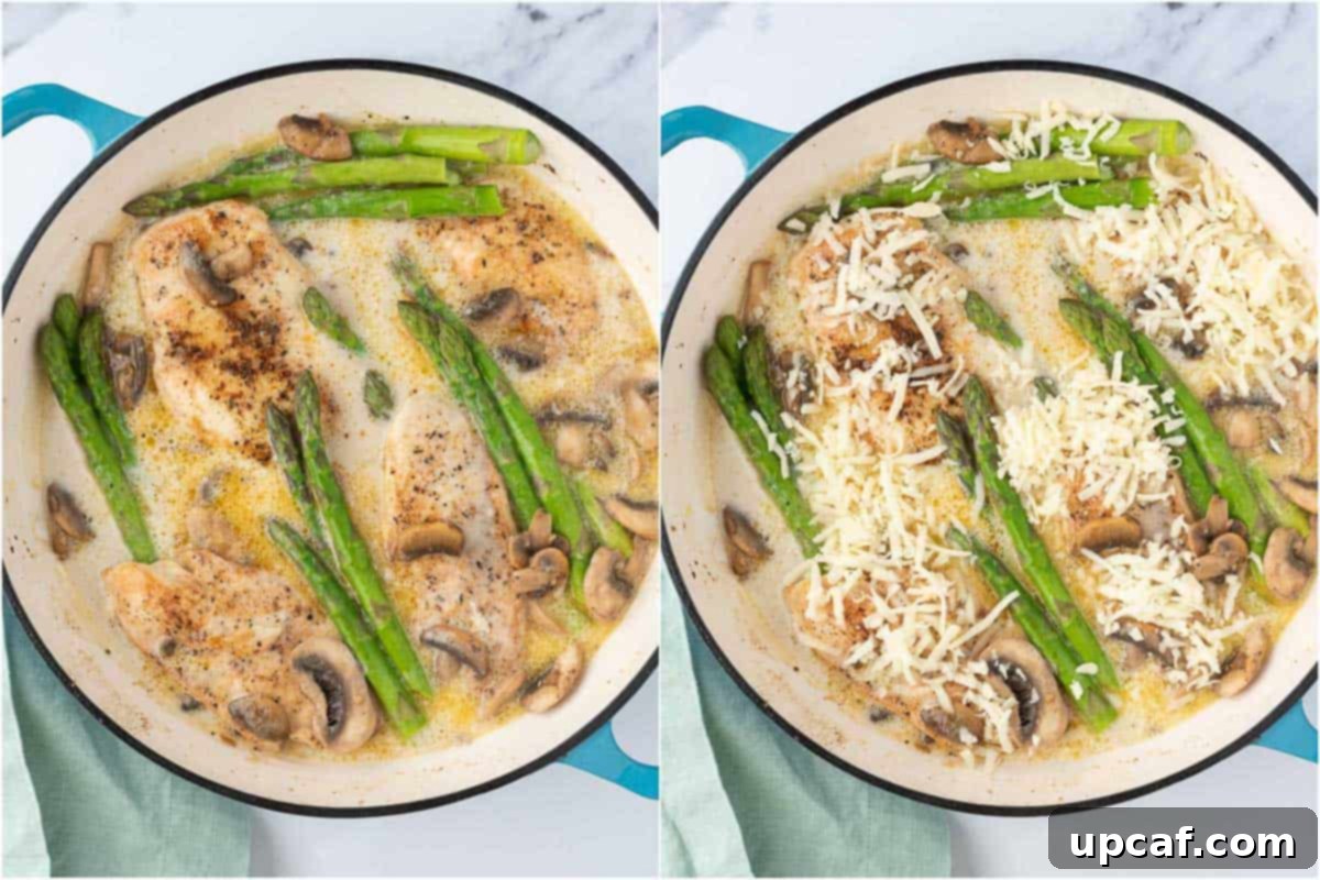 Seared chicken breasts and blanched asparagus returned to the pot of creamy sauce, with shredded mozzarella cheese sprinkled on top, ready for broiling.
