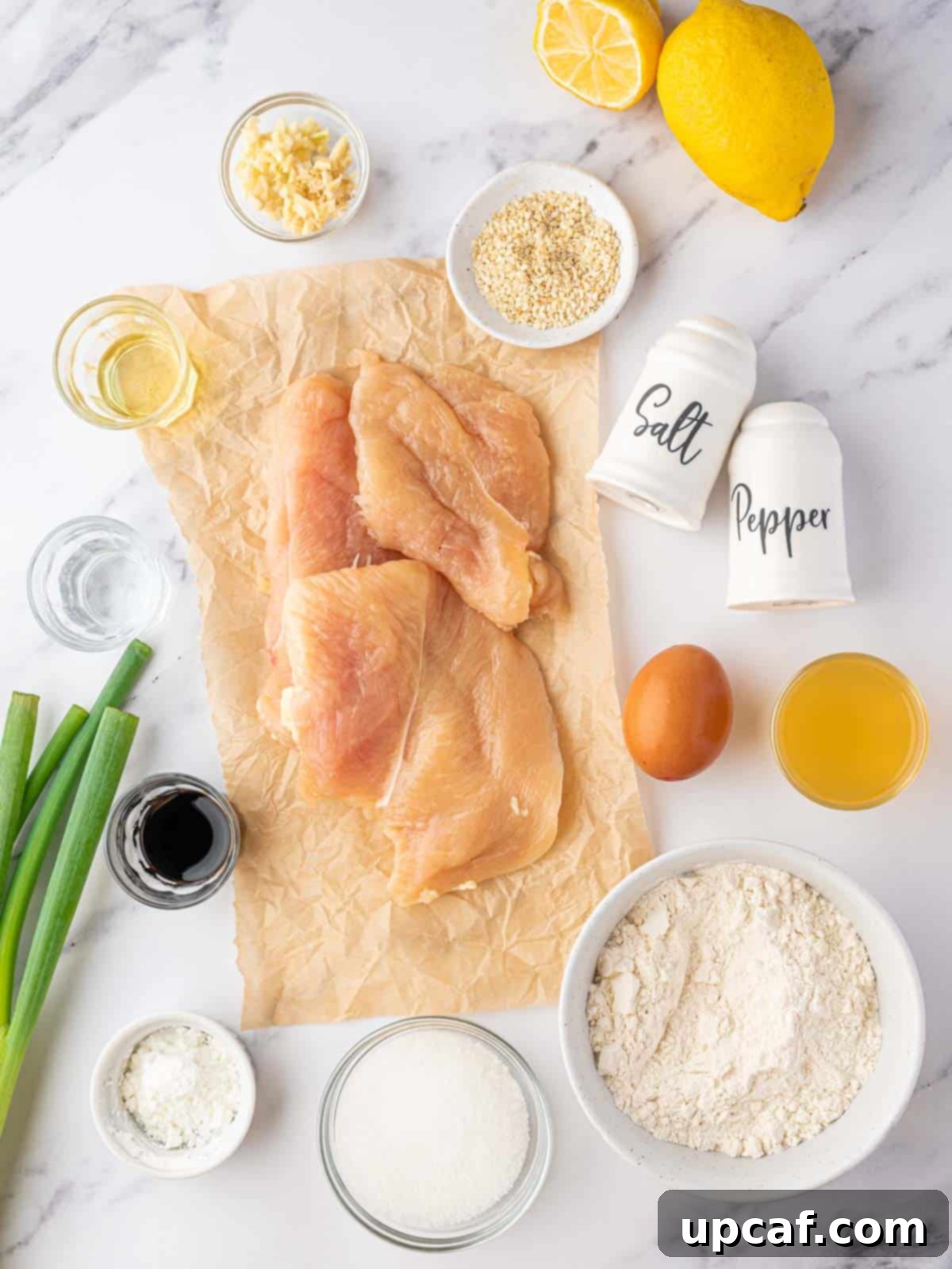 A vibrant flat lay showcasing all the fresh ingredients needed for Chinese Lemon Chicken, including chicken, lemons, sauces, and spices.