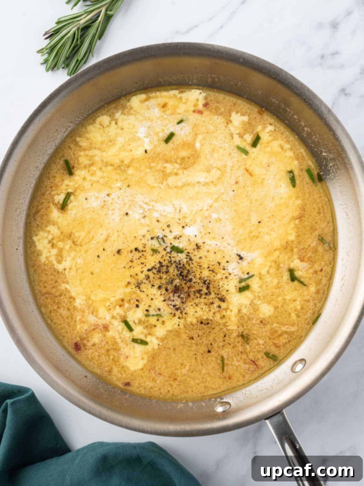 Adding heavy cream to the simmering mustard sauce for richness.