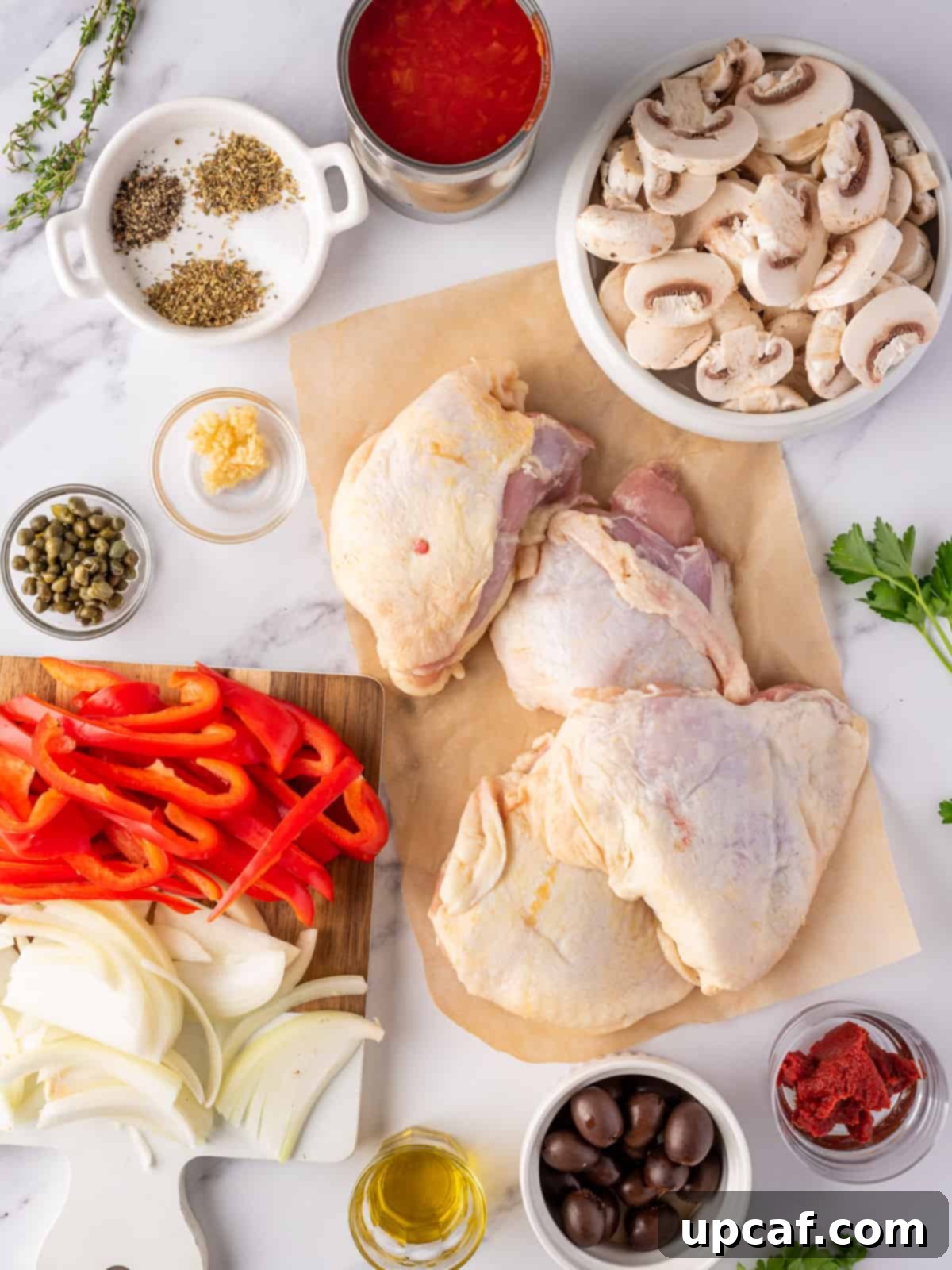 Fresh ingredients needed for making easy chicken cacciatore, including chicken thighs, vegetables, and herbs.